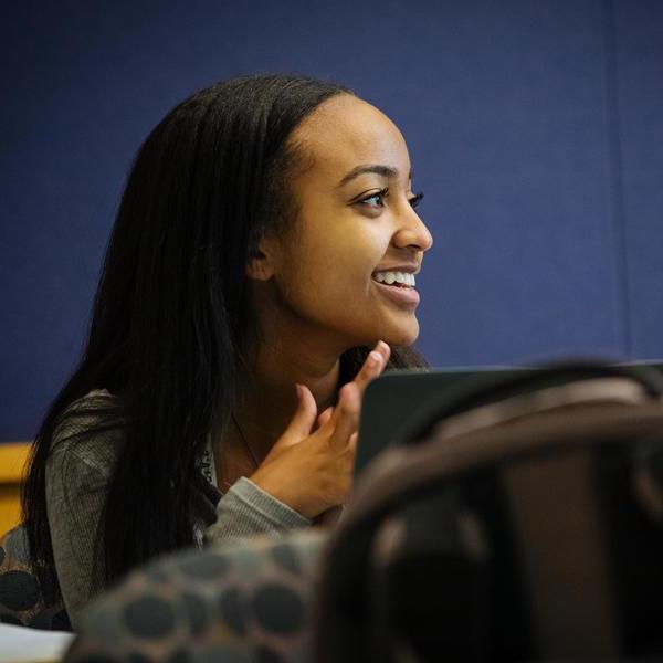 Asian studies student listening and smiling in class.