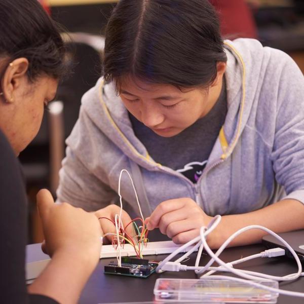 An engineering major student wiring a circuit board.