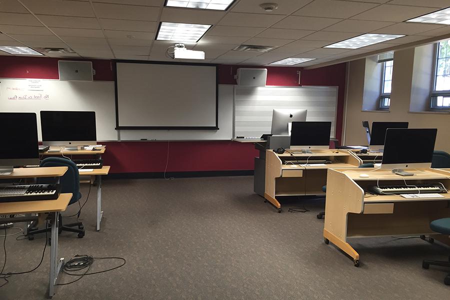 View of Presser G19 with Apple computers, musical keyboards, projection screen, and whiteboard with musical staff